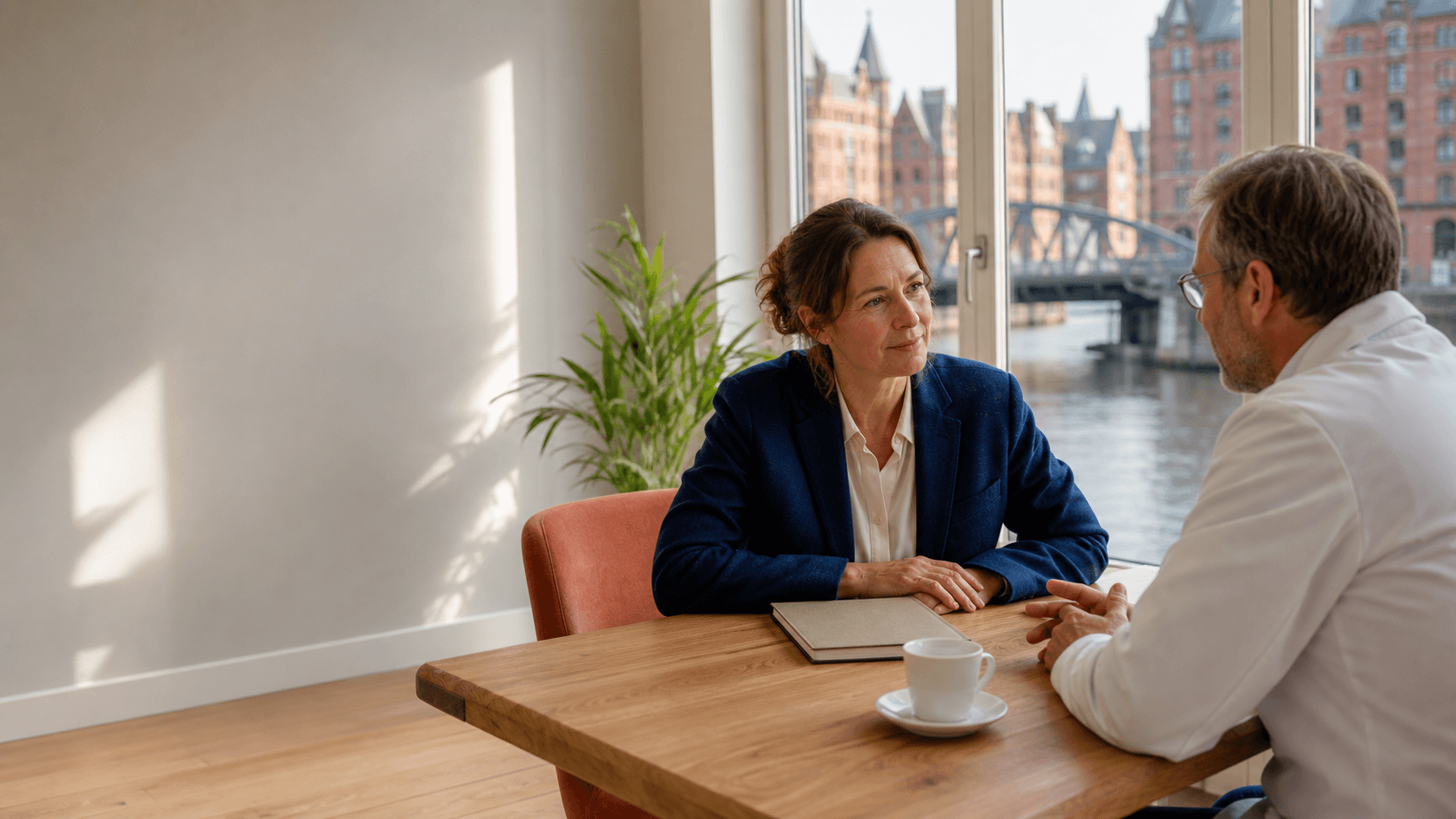 A Dudoxx specialist listens to a clinic director beside a Hamburg canal view