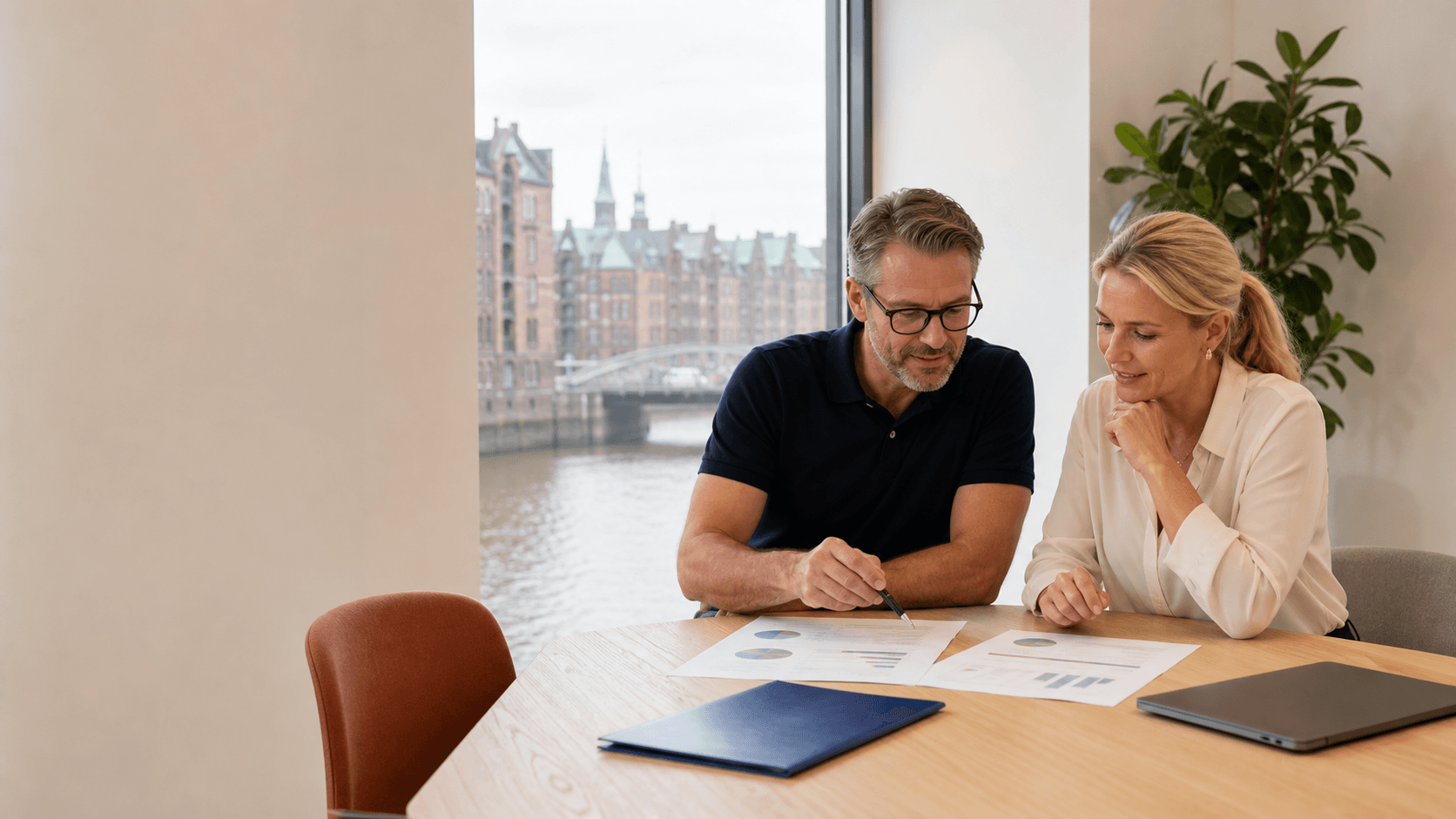 A clinic owner and practice manager review a clear budget with Hamburg’s Speicherstadt outside